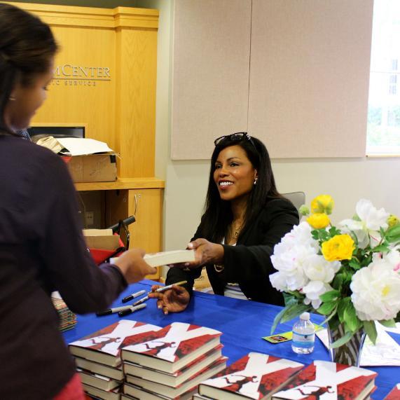 ilyasah shabazz signs her book.