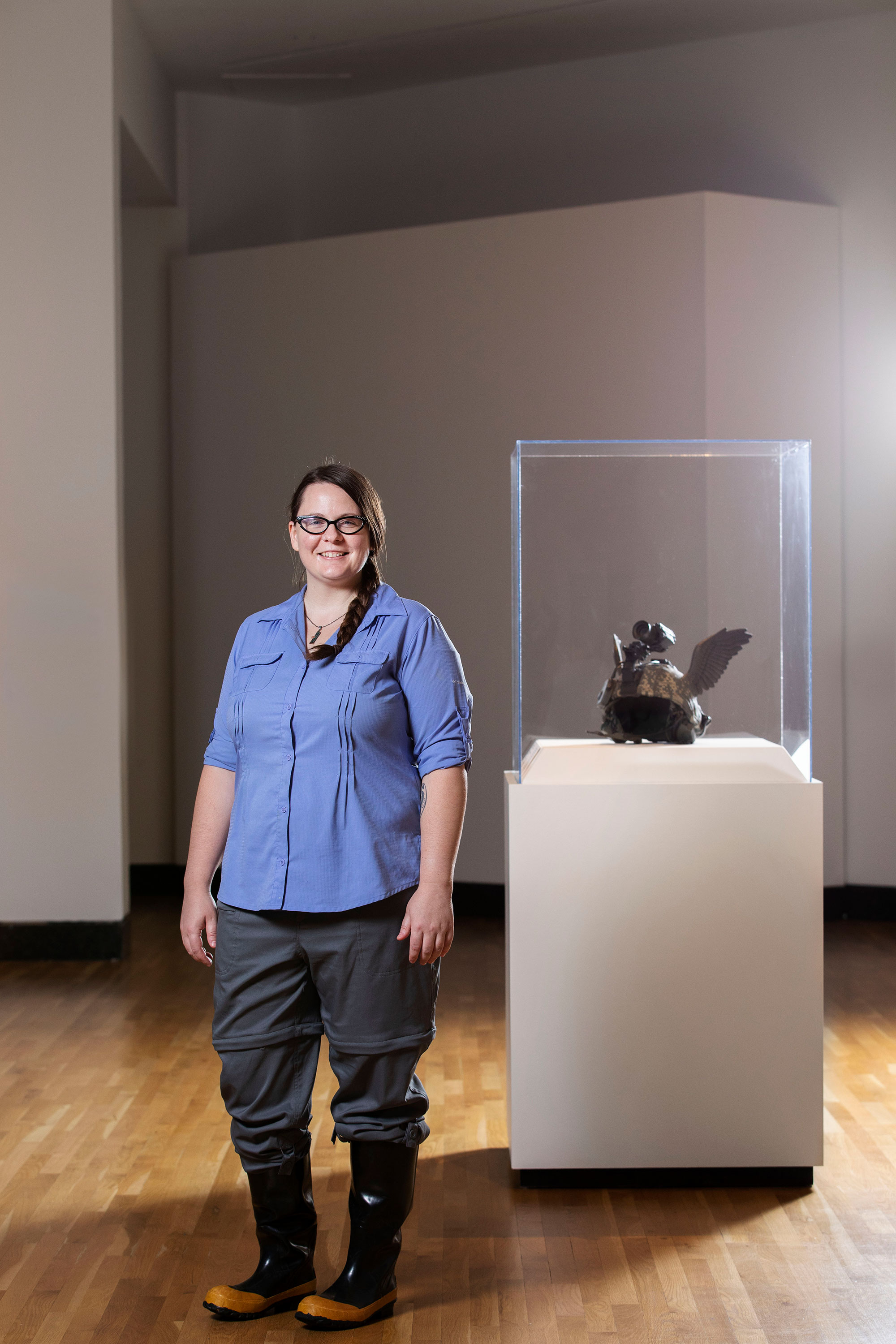 Kirsten Hecht with a helmet sculpture at the Harn